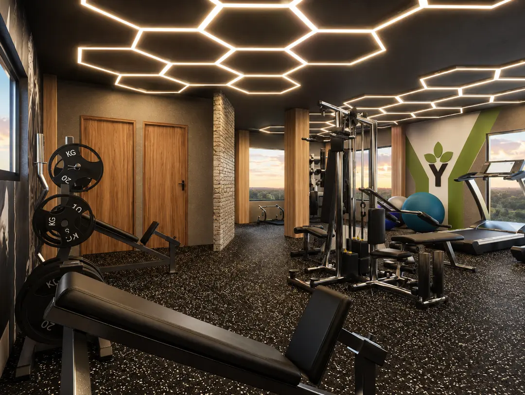 Gimnasio de Embassy Gardens con máquinas de fuerza, cardio y ventanales hacia las áreas verdes